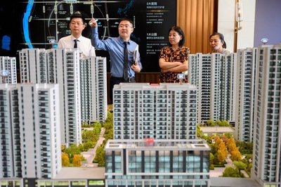 2023年6月21日,太原,一售楼部销售人员为民众推介商品房户型 视觉中国图